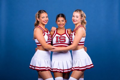 Cheerleaders posing together on blue backdrop