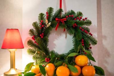 Festive wreath and oranges on table