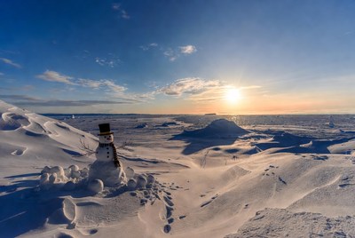 Snowman in a winter landscape at sunset