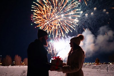 Couple exchanging gifts during fireworks