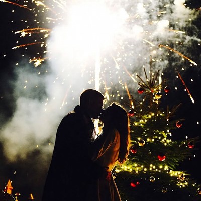 Couple kisses under fireworks display