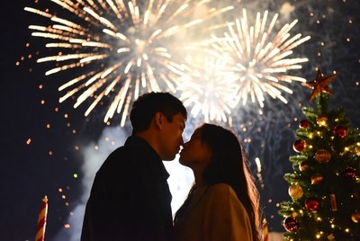 Couple kissing under fireworks display