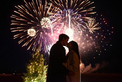 Couple kissing under fireworks display