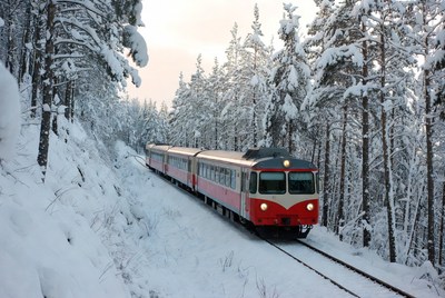 Winter train journey through snow-covered forest