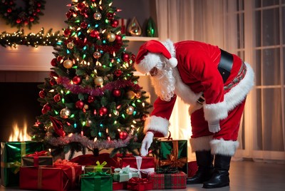 Santa preparing gifts by the christmas tree