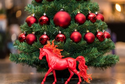 Festive red horse under christmas tree
