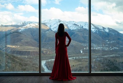 Woman in red dress gazing at mountains