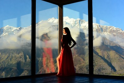 Woman in red dress by mountain view