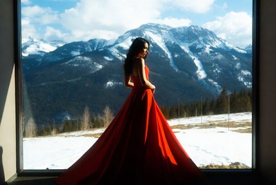 Woman in red dress by mountains