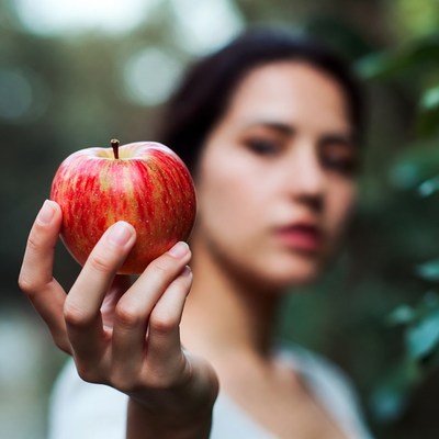 Woman holding a fresh apple outdoors