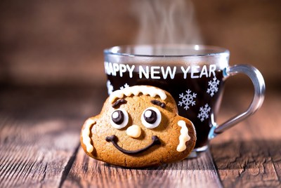 Gingerbread cookie beside steaming coffee