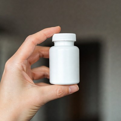 Holding a white supplement bottle