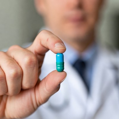 Doctor holding blue capsule in clinic