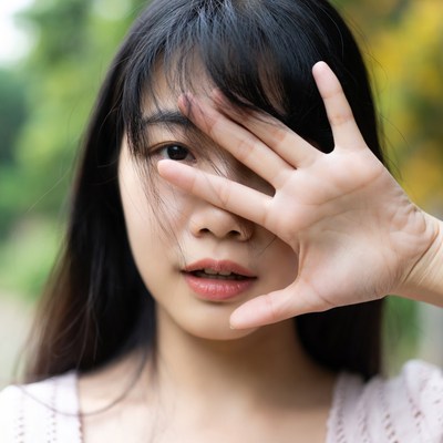 Young woman covering her face