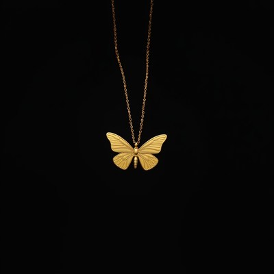 Gold butterfly necklace on dark background