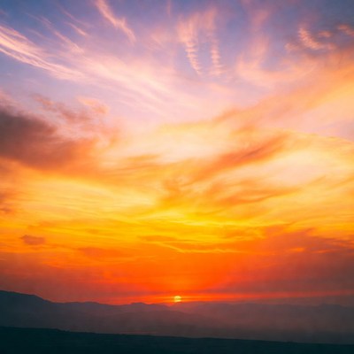 Sunset over mountain range in evening sky