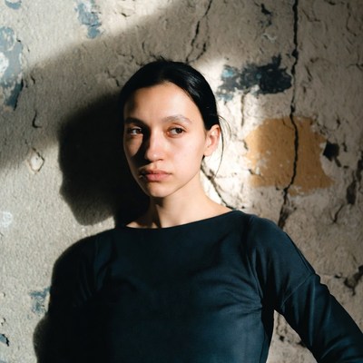 Woman posing near textured wall