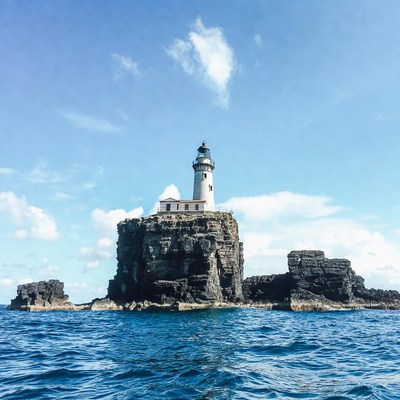 Lighthouse on rocky island at sea