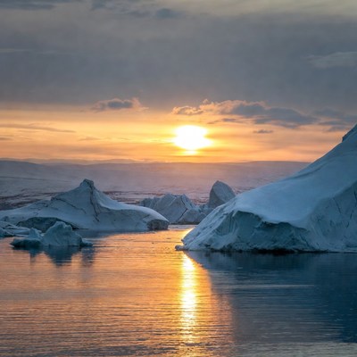 Sunset over icebergs in calm waters