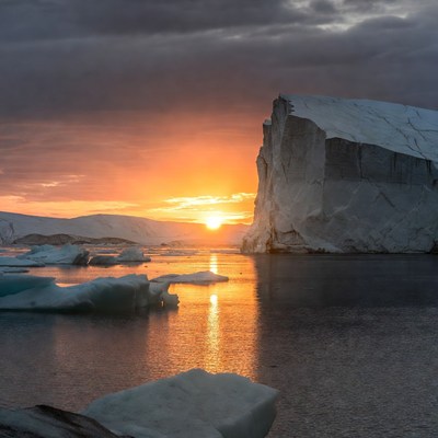 Sunset over icebergs in ocean