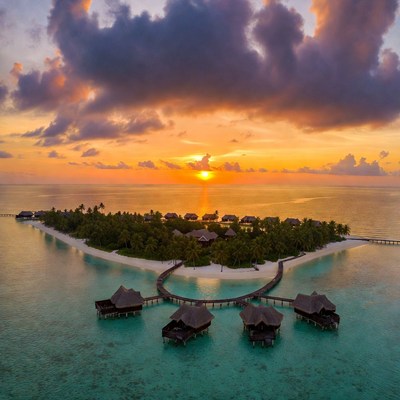 Sunset over island resort with water villas