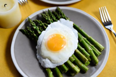 Egg on asparagus plate served at breakfast