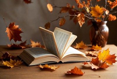 Open book with autumn leaves and flowers