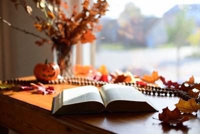 Open book on a table with autumn leaves