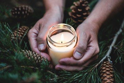 Holding candle among pine branches