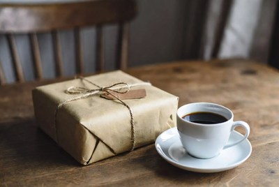 Wrapped gift and coffee on table