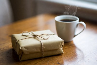Coffee and wrapped gift on table