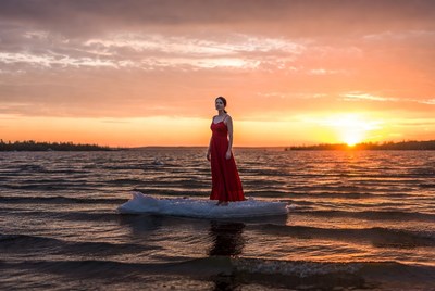 Woman standing on ice at sunset