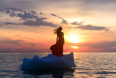 Woman on iceberg at sunset