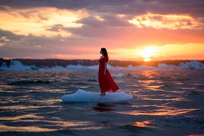Woman standing on ice at sunset