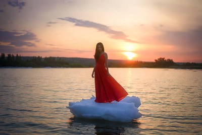 Woman stands on ice at sunset
