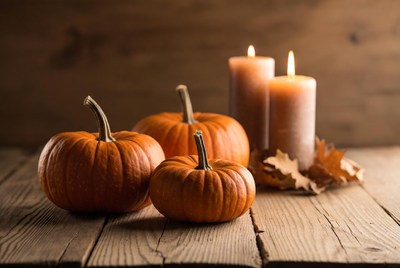 Pumpkins and candles on wooden table