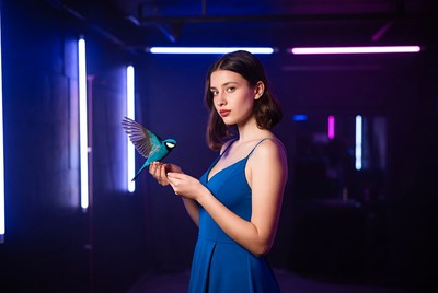 Model holding bird in neon room