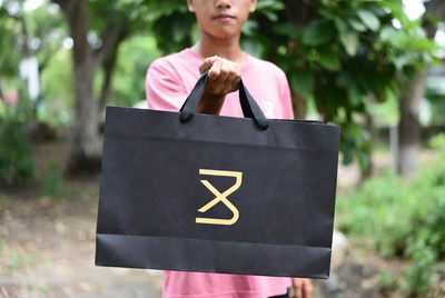 Young person holding shopping bag outdoors
