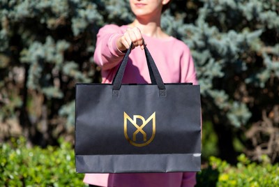 Woman holds bag in park