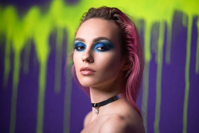 Model posing against colorful backdrop