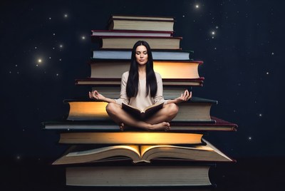 Woman meditating on stacked books