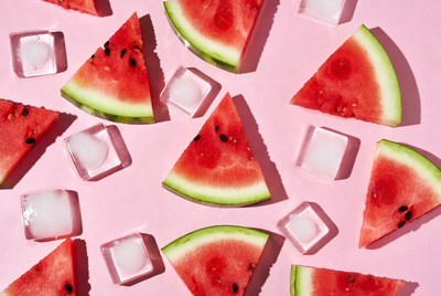 Watermelon slices with ice on pink background