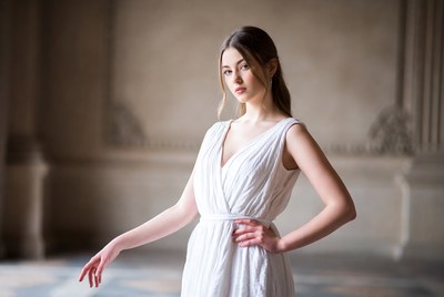Model poses indoors in light dress