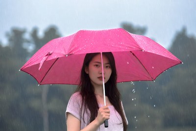 Woman with pink umbrella in rain