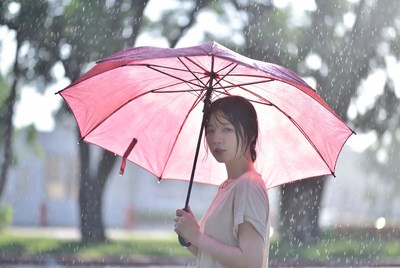 Woman holding red umbrella in rain