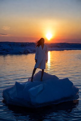Woman standing on ice at sunset
