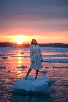 Model stands on ice at sunset