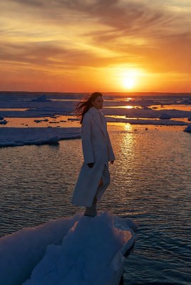 Woman standing on ice at sunset