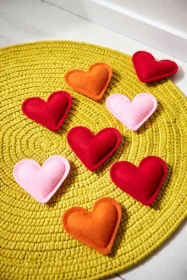 Colorful felt hearts on yellow mat