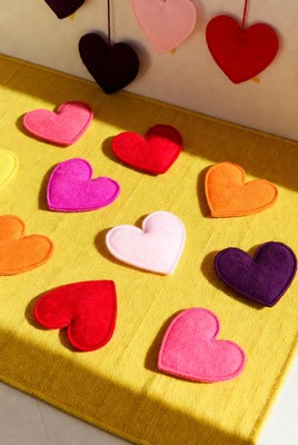 Colorful felt hearts on yellow fabric